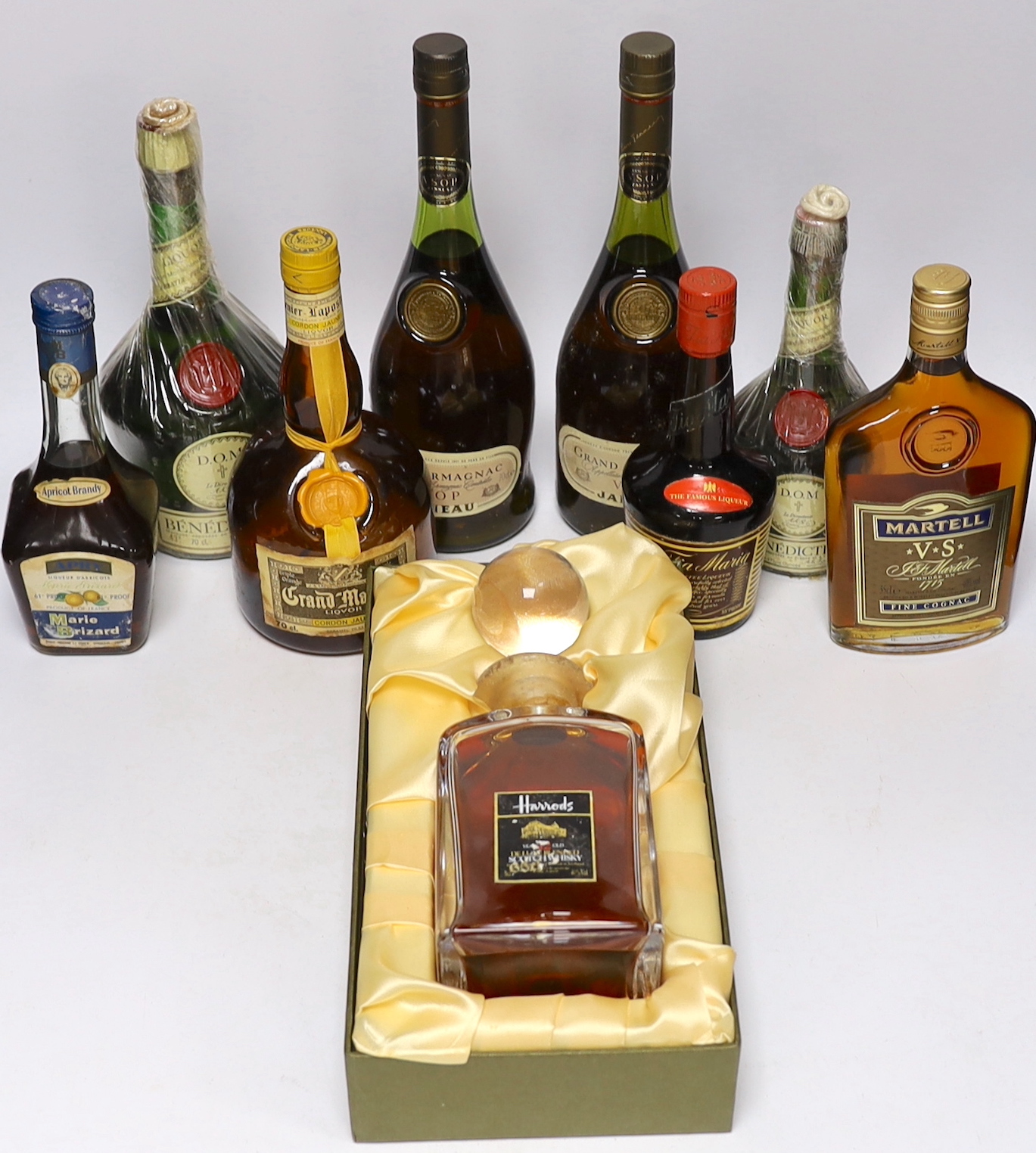 A bottle of Harrods Whisky, 12 years old, two bottles of Janneau VSOP Grand Armagnac, a bottle of Grand Marnier Cordon Jaune, one and a half bottles of D.O.M Benedictine, half a bottle of Martell V.S Fine Connacht, a bot